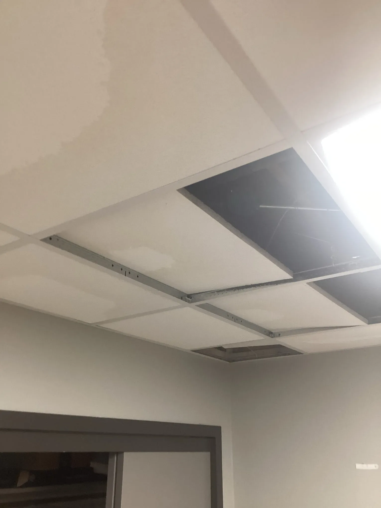 Suspended ceiling tiles stained and sagging where water has come through from above