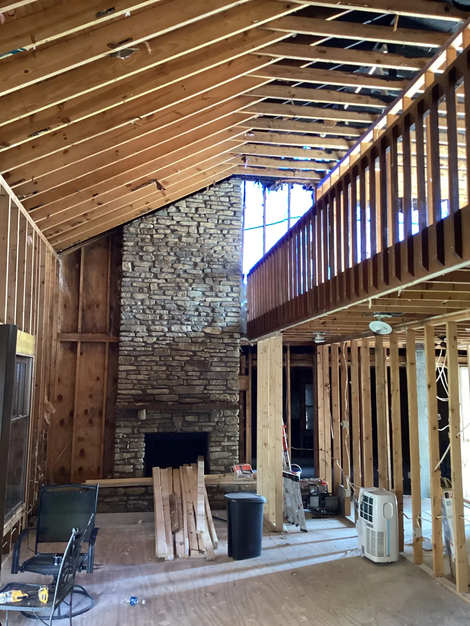 Interior gutted back to framing after a fire, with a stone fireplace still standing