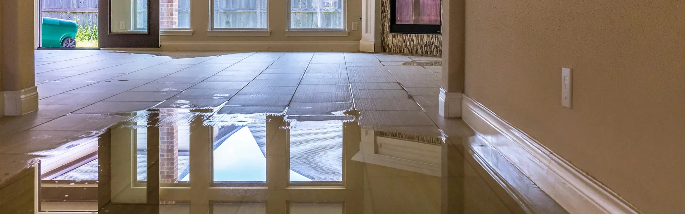 Standing water lying across a hardwood hallway floor before extraction